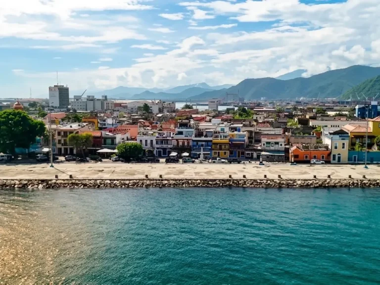 Malecón de Puerto Cabello con casas de colores frente al mar y montañas al fondo