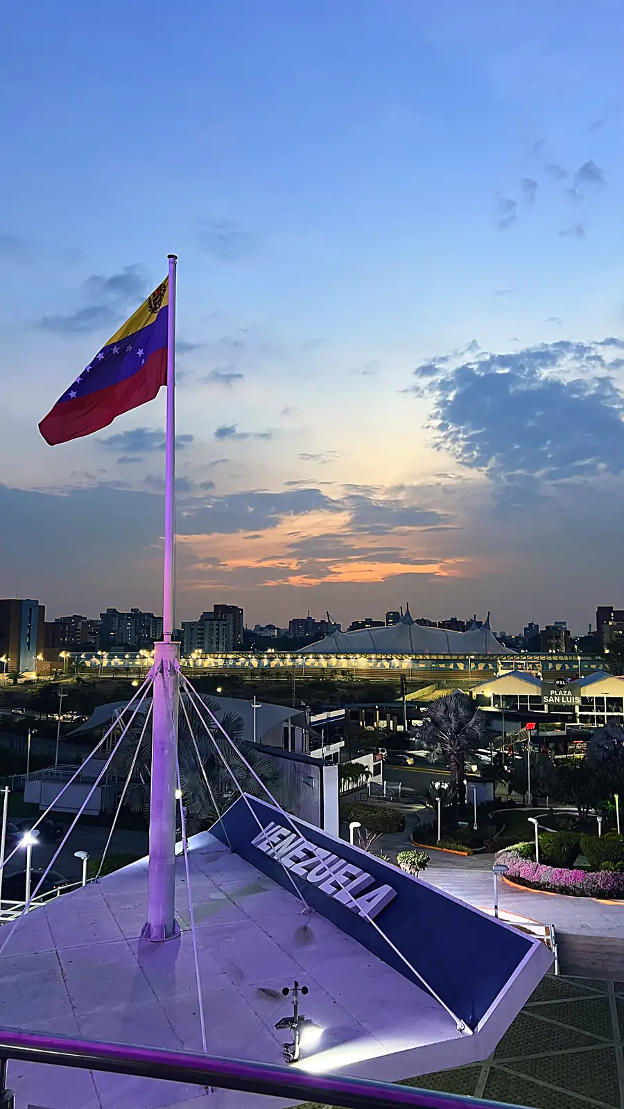 Bandera de Venezuela ondeando junto a la Flor de Venezuela en Barquisimeto al atardecer, zona de traslados de Prince Tours